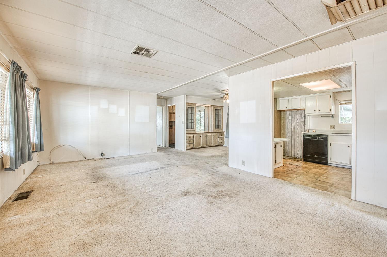 1300 West Olson Avenue, Unit 75 Reedley, CA 93654 - Photo 7 of 40 an empty room with kitchen view and a window