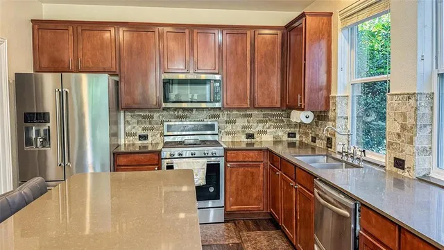 a kitchen with stainless steel appliances a refrigerator sink and cabinets