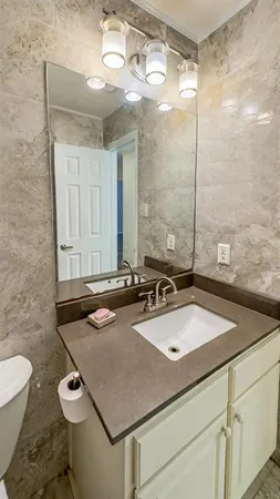a bathroom with a granite countertop sink and a mirror