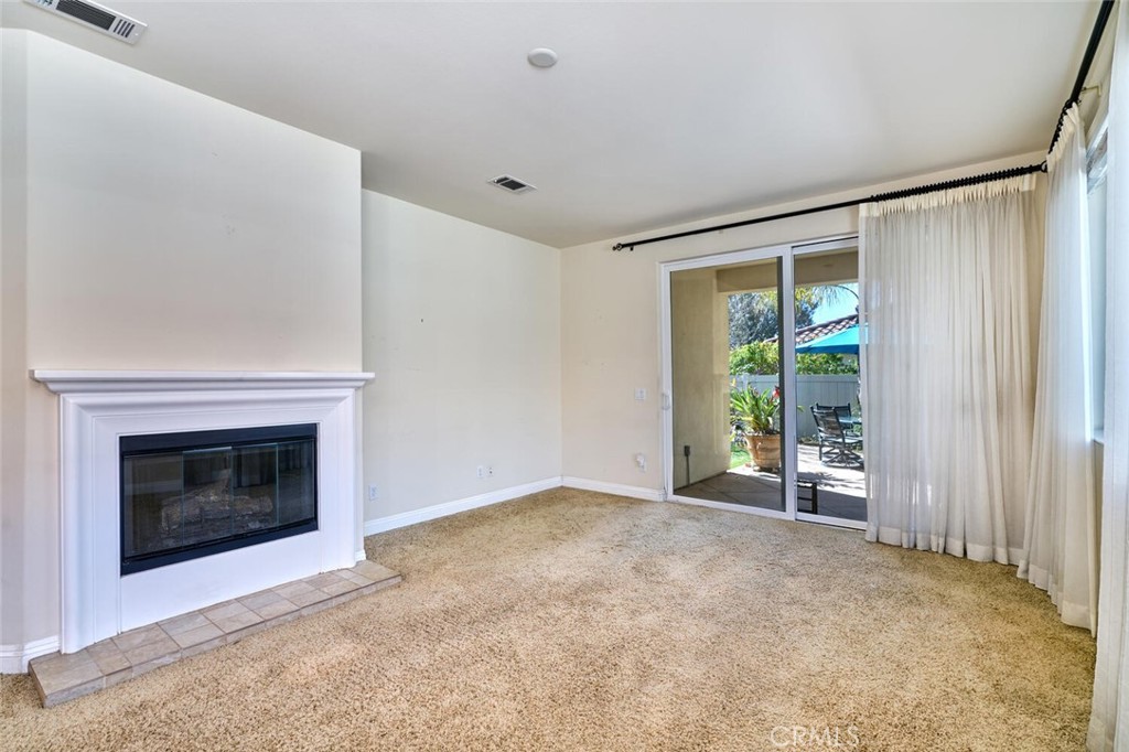 1143 Saguara Road Beaumont, CA 92223 - Photo 34 of 66 a view of an empty room with a fireplace and a window