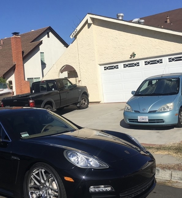 a black car parked in front of a house