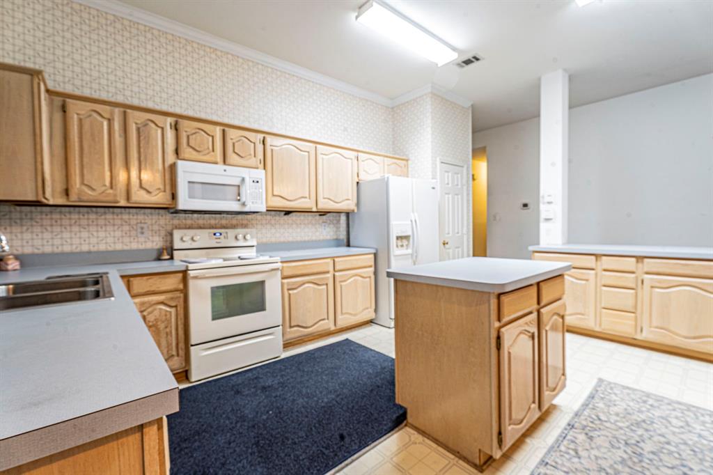 8317 Lake Bend Drive Rowlett, TX 75088 - Photo 11 of 35 Kitchen featuring white appliances, light flooring, a kitchen island