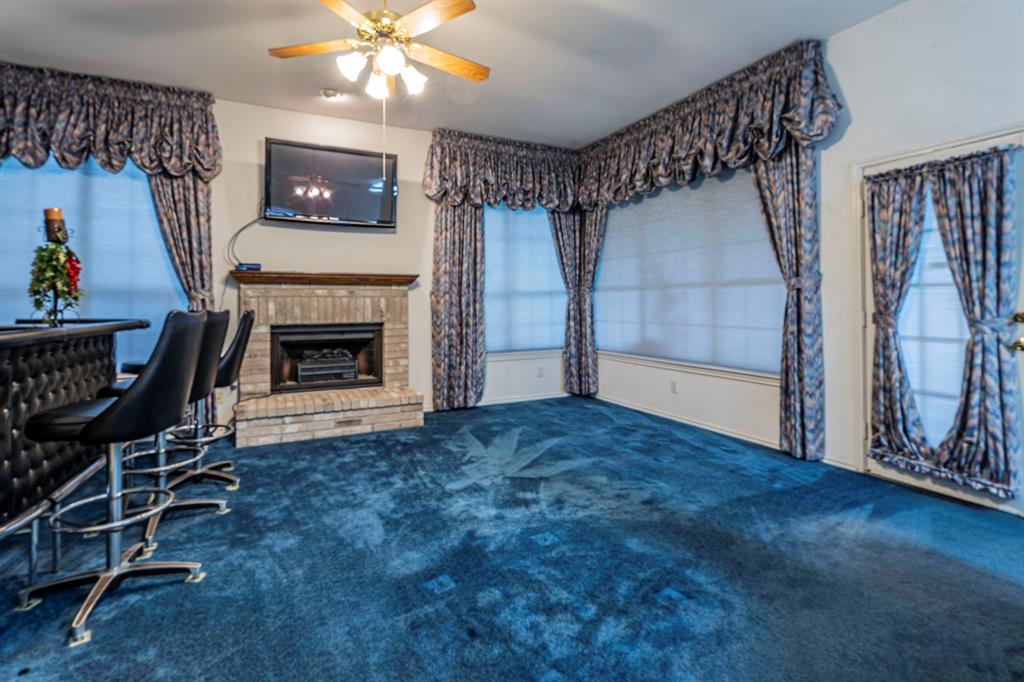 8317 Lake Bend Drive Rowlett, TX 75088 - Photo 12 of 35 Den area featuring carpet, ceiling fan, healthy amount of natural light, and a fireplace