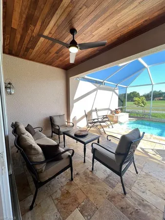 a living room with patio furniture and a floor to ceiling window