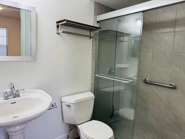 a bathroom with a sink toilet and shower
