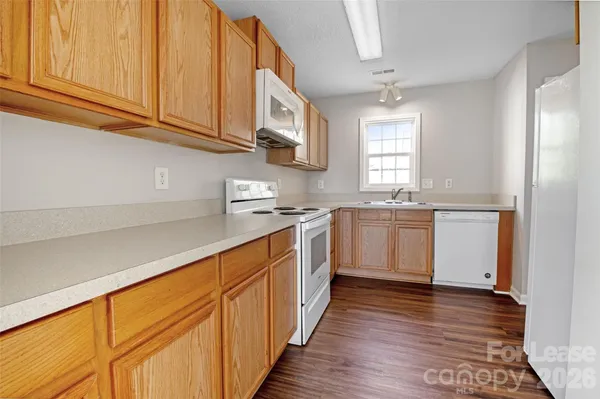 a kitchen with stainless steel appliances granite countertop a sink a stove cabinets and wooden floor