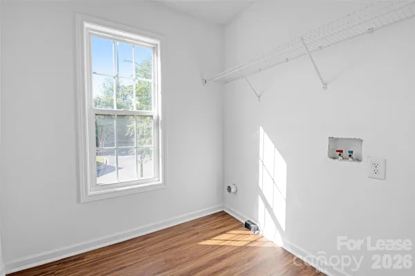 an empty room with windows and chandelier fan
