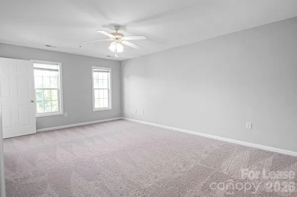 a view of an empty room with a ceiling fan