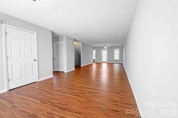 a view of an empty room with wooden floor