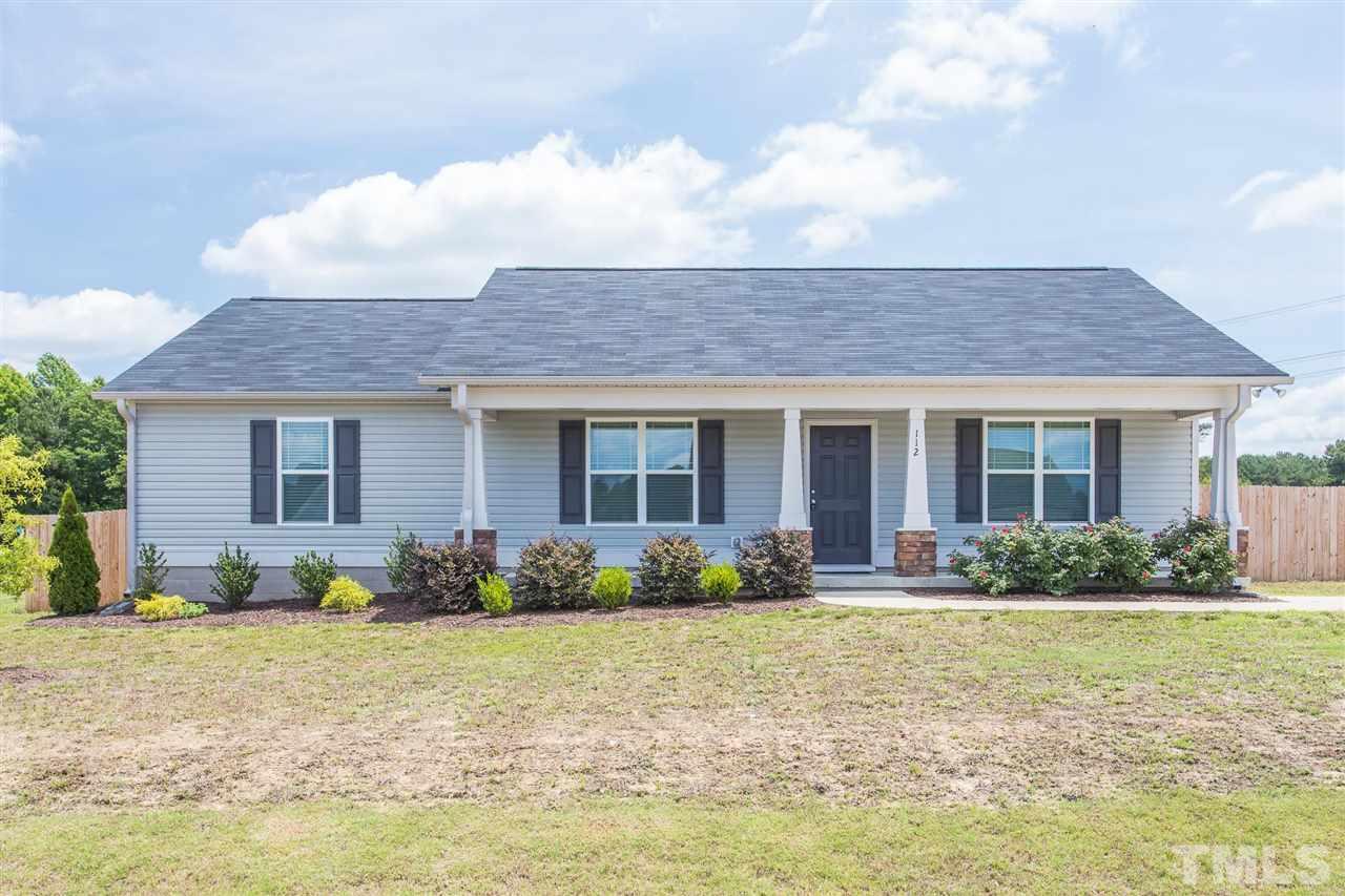112 Willow Ridge Circle Willow Spring, NC 27592 - Photo 1 of 30 a front view of a house with garden and porch