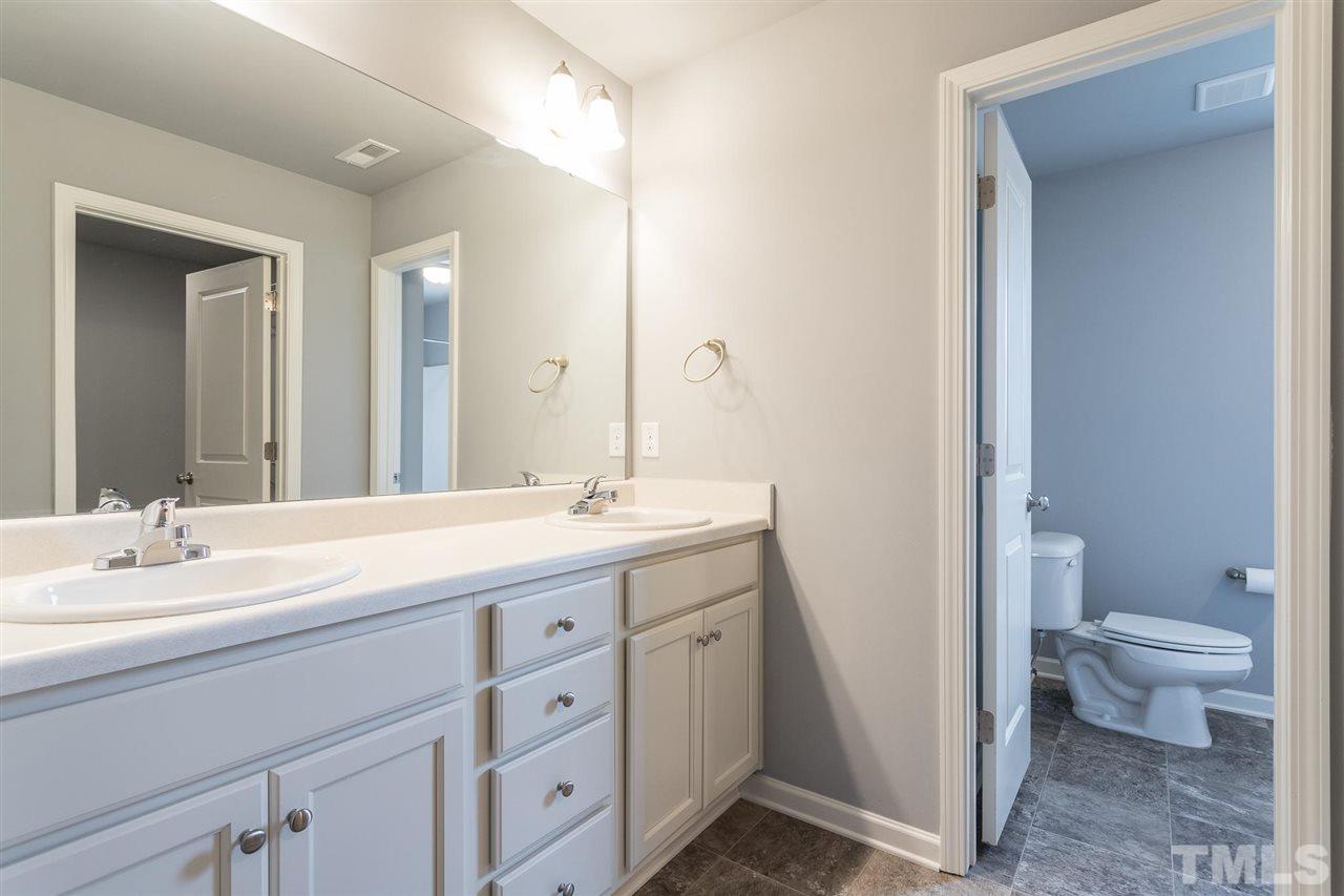 112 Willow Ridge Circle Willow Spring, NC 27592 - Photo 23 of 30 a spacious bathroom with a double vanity sink toilet and a mirror