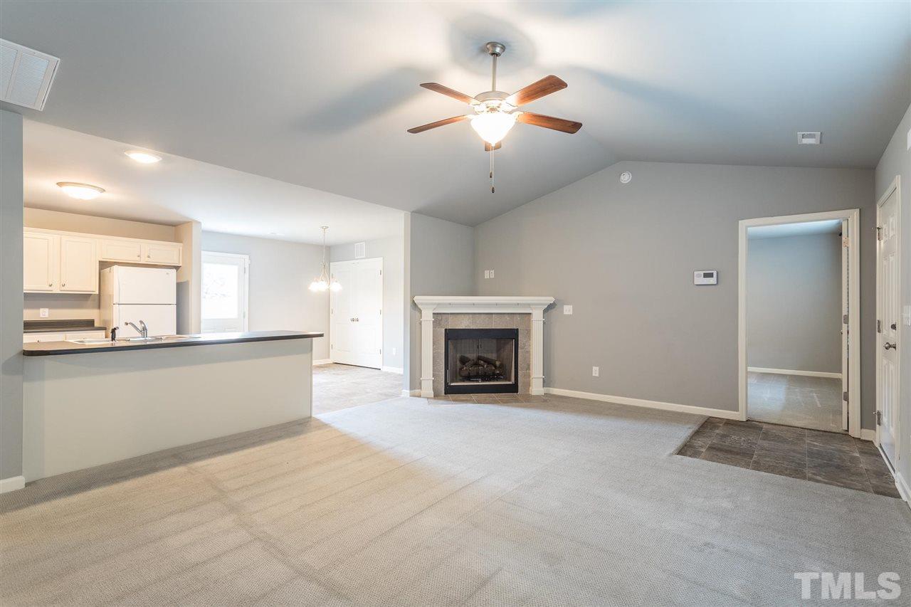 112 Willow Ridge Circle Willow Spring, NC 27592 - Photo 8 of 30 an empty room with a fireplace and fan