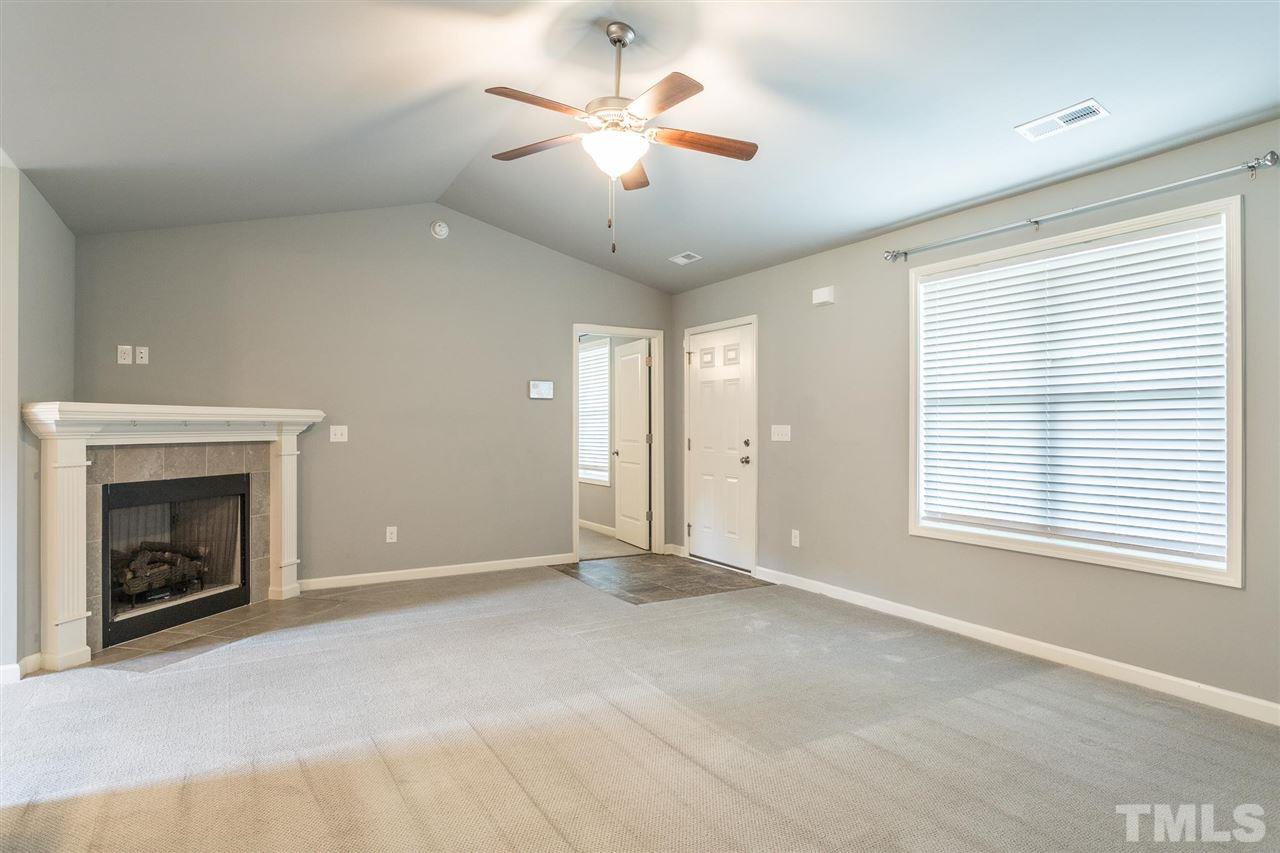 112 Willow Ridge Circle Willow Spring, NC 27592 - Photo 9 of 30 a view of an empty room with chandelier fan and fire place