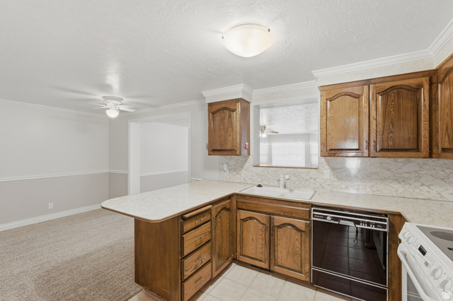 148 Tennyson Avenue Sandy, UT 84070 - Photo 10 of 55 Kitchen featuring wood cabinetry, white countertops with integrated sink, and a black built-in dishwasher