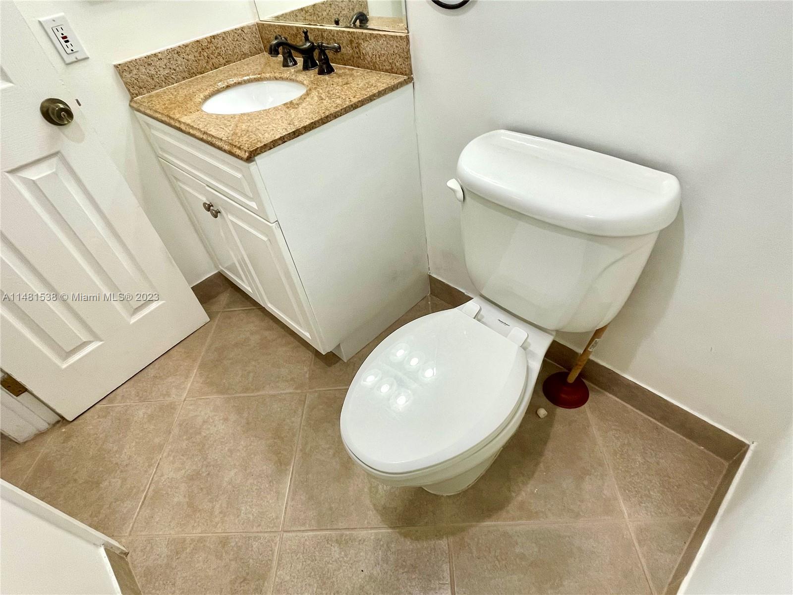 5100 Southwest 90th Avenue, Unit 303 Cooper City, FL 33328 - Photo 19 of 36 a bathroom with a toilet sink and mirror