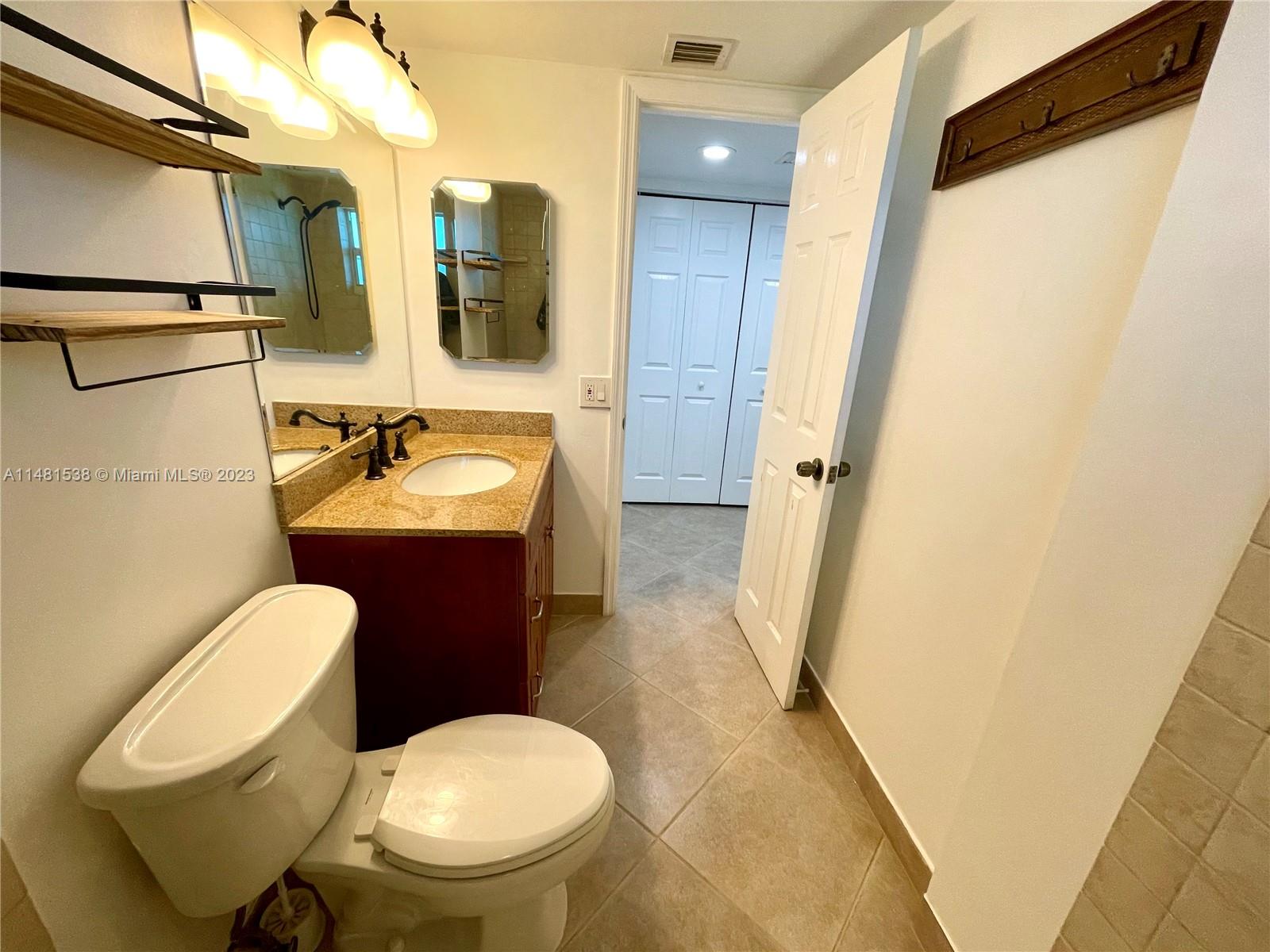 5100 Southwest 90th Avenue, Unit 303 Cooper City, FL 33328 - Photo 24 of 36 a bathroom with a toilet sink and mirror