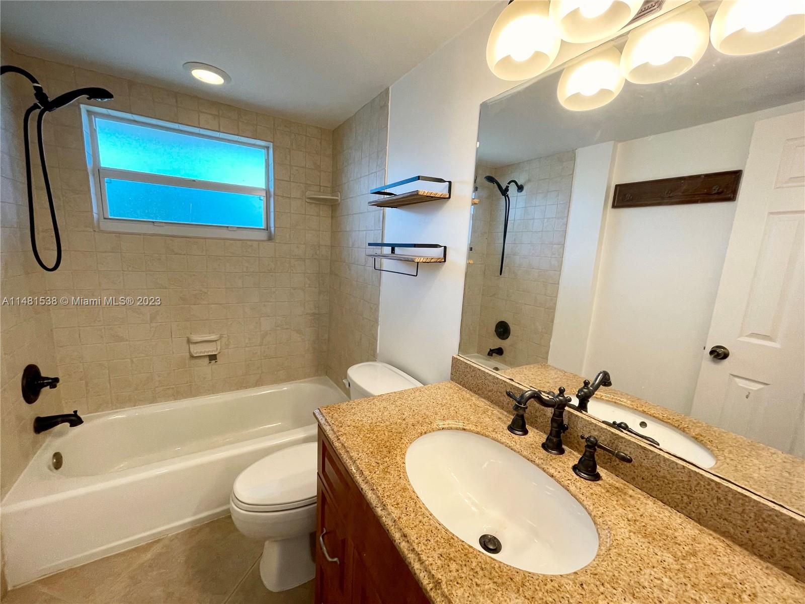 5100 Southwest 90th Avenue, Unit 303 Cooper City, FL 33328 - Photo 26 of 36 a bathroom with a granite countertop sink and a mirror