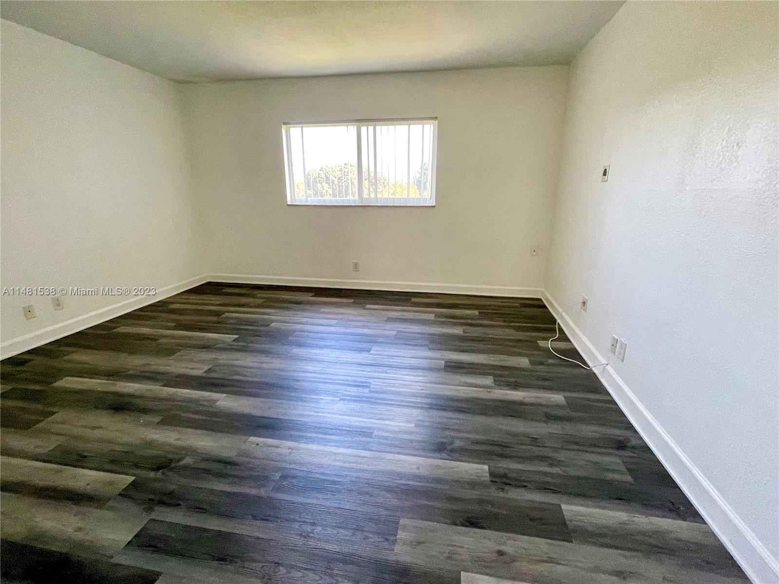 5100 Southwest 90th Avenue, Unit 303 Cooper City, FL 33328 - Photo 31 of 36 an empty room with wooden floor and windows