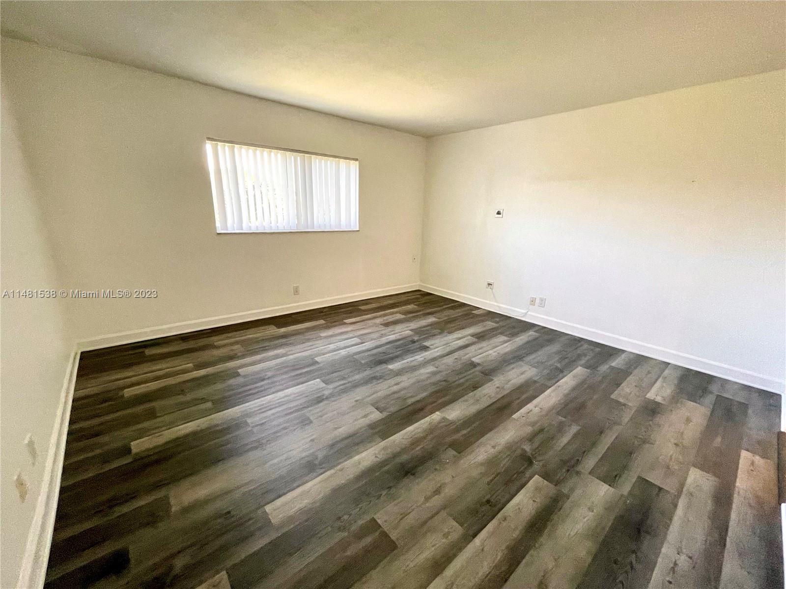 5100 Southwest 90th Avenue, Unit 303 Cooper City, FL 33328 - Photo 33 of 36 a view of an empty room with wooden floor and a window