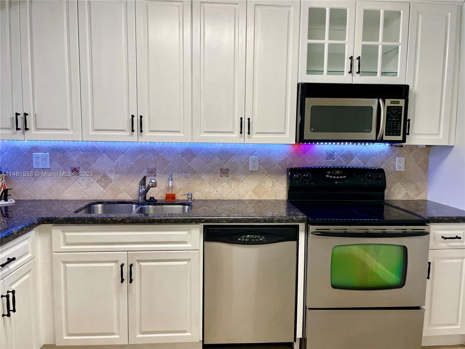 5100 Southwest 90th Avenue, Unit 303 Cooper City, FL 33328 - Photo 8 of 36 a kitchen with a stove and a microwave