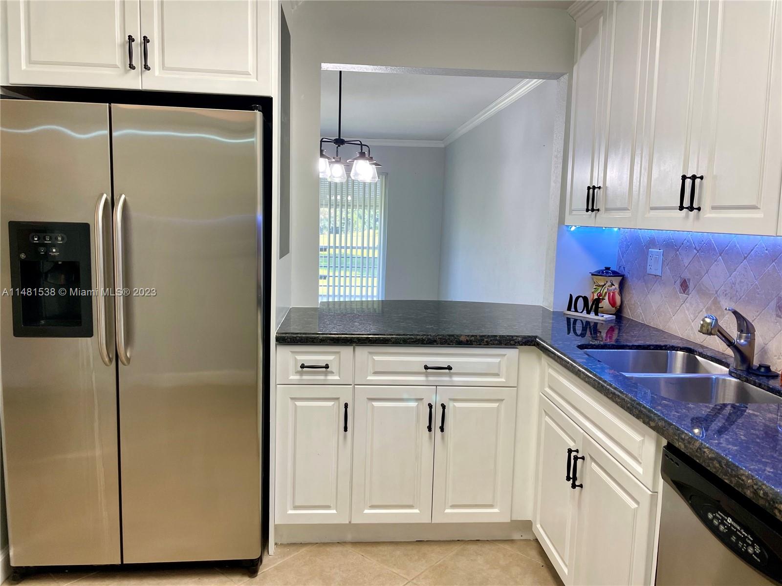 5100 Southwest 90th Avenue, Unit 303 Cooper City, FL 33328 - Photo 9 of 36 a kitchen with a refrigerator sink and cabinets