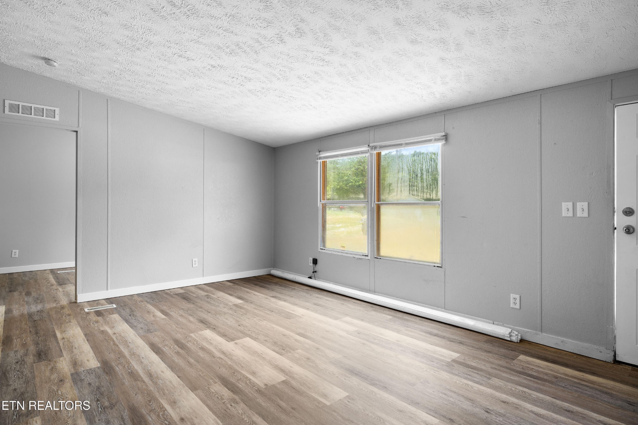 1768 Fain Cemetery Road Dandridge, TN 37725 - Photo 13 of 45 an empty room with wooden floor and windows