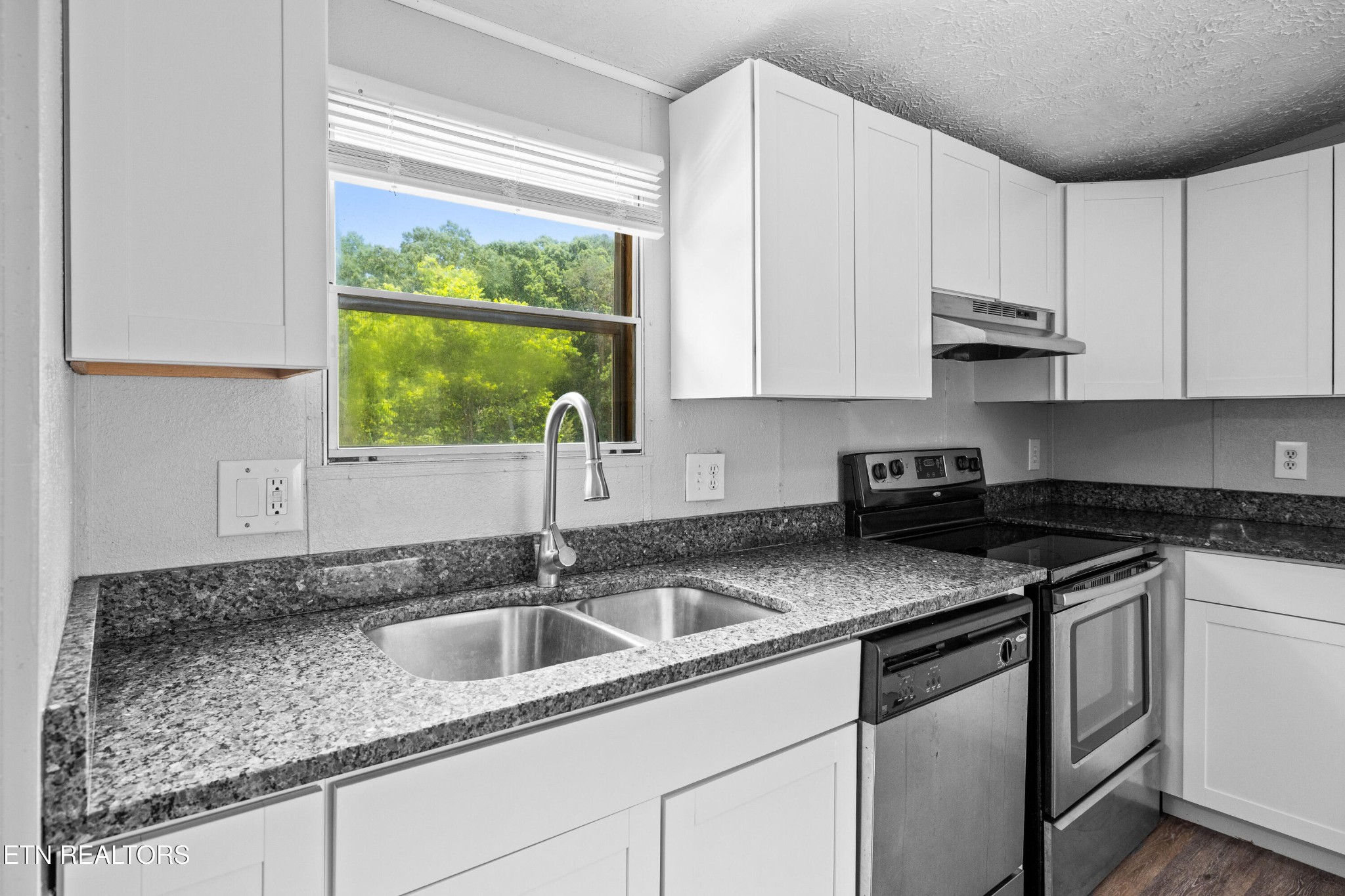 1768 Fain Cemetery Road Dandridge, TN 37725 - Photo 10 of 45 a kitchen with stainless steel appliances granite countertop a sink stove and cabinets