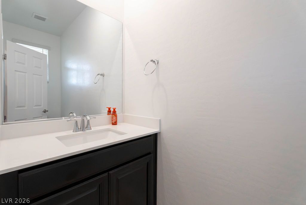 7126 Calvert Cliffs Street North Las Vegas, NV 89084 - Photo 2 of 44 A sleek vanity with a wide mirror offers functional elegance in this well-appointed bathroom.