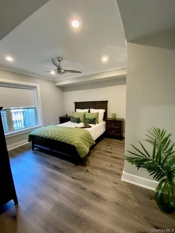 a bedroom with a bed window and wooden floor