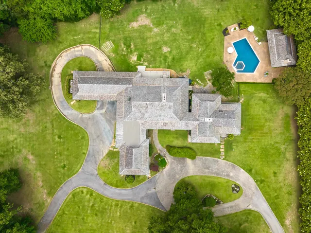 an aerial view of a house with outdoor space and swimming pool
