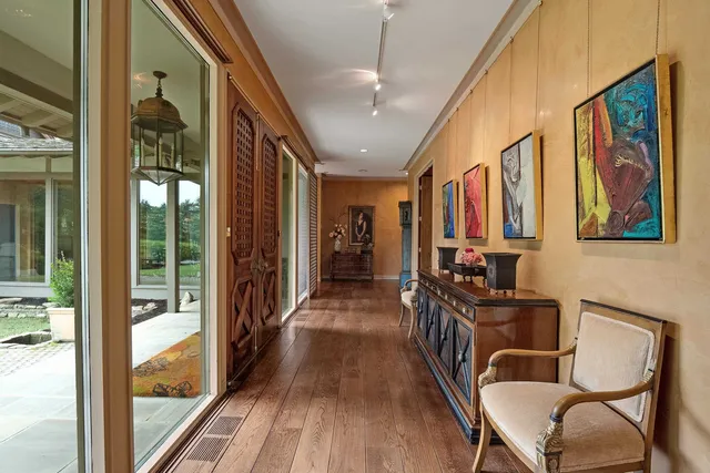 a view of a hallway with wooden floor and stairs