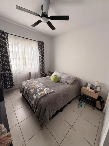 a bedroom with a bed and a chandelier fan