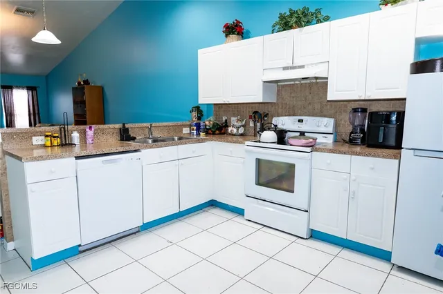 a kitchen with white cabinets and white appliances