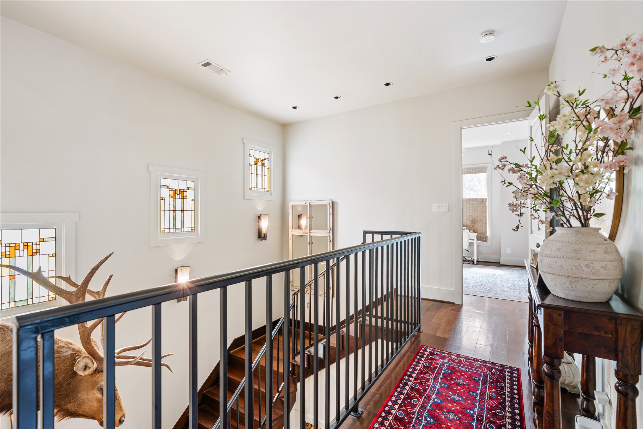 926 Nicholson Street Houston, TX 77008 - Photo 17 of 36 Custom Frank Lloyd Wright-inspired stained glass windows illuminate the upper landing, adding character and artistry to the home's central staircase.
