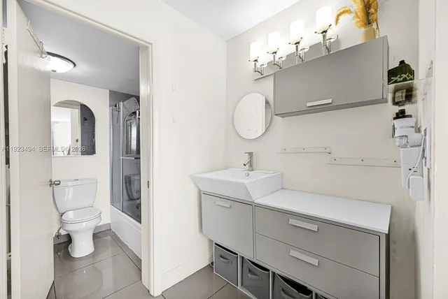 a bathroom with a sink a toilet and mirror