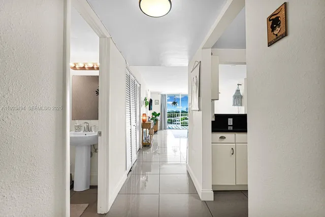 a view of a hallway with bathroom and wooden floor