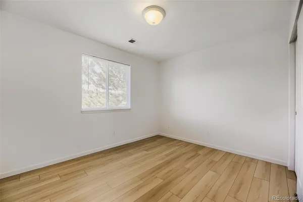 a view of empty room with wooden floor