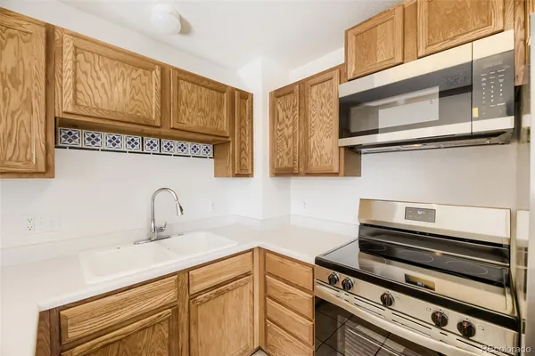 a view of a kitchen with white cabinets and a window