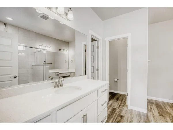 a bathroom with a sink vanity granite tub shower and a mirror