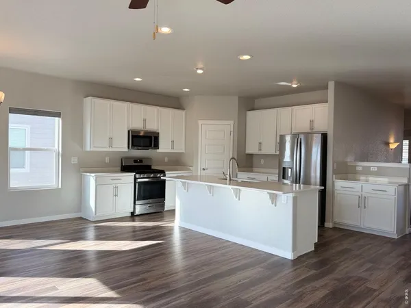 a kitchen with a refrigerator stove and wooden cabinets