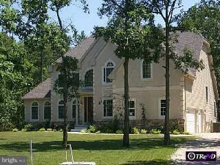 a front view of a house with a yard and trees
