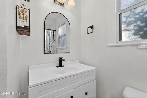 a bathroom with a toilet sink and mirror