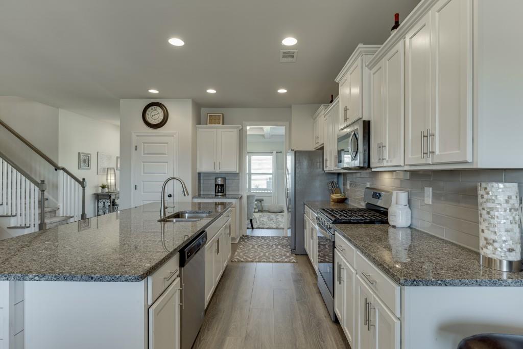 558 Calgary Downs Drive Winder, GA 30680 - Photo 14 of 50 a kitchen with stainless steel appliances granite countertop a sink a stove and a refrigerator