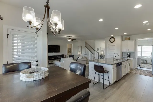 a living room with stainless steel appliances kitchen island granite countertop furniture a fireplace and a large window