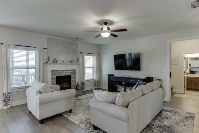 a living room with furniture a flat screen tv and a fireplace