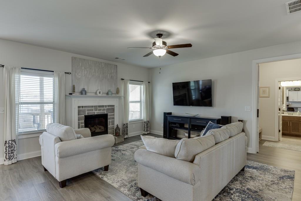 558 Calgary Downs Drive Winder, GA 30680 - Photo 18 of 50 a living room with furniture a flat screen tv and a fireplace