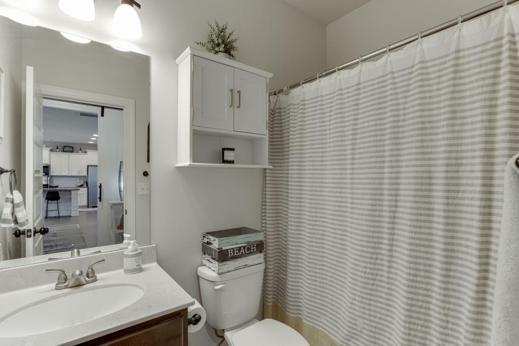 558 Calgary Downs Drive Winder, GA 30680 - Photo 24 of 50 a bathroom with a sink a toilet and shower curtain