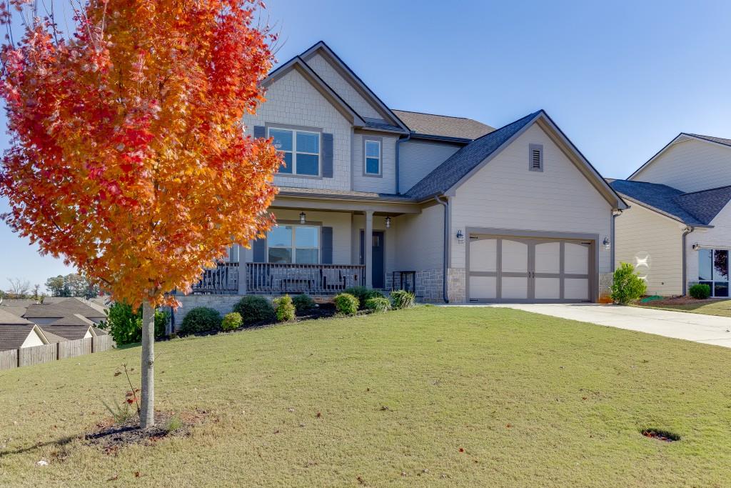 558 Calgary Downs Drive Winder, GA 30680 - Photo 3 of 50 a front view of a house with a yard and garage