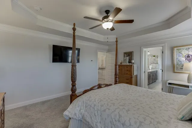 a bedroom with a bed and a flat tv screen on dresser