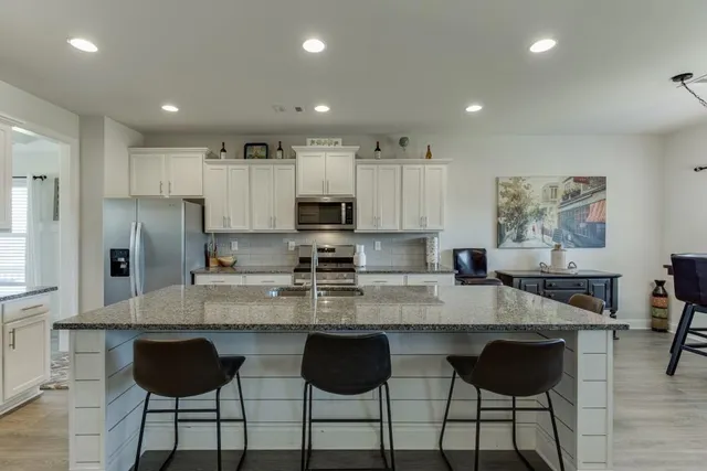 a kitchen with granite countertop a counter top space cabinets and stainless steel appliances